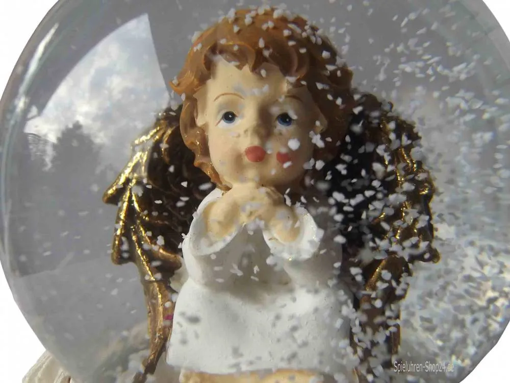 Verträumte Engel Putte in Spieluhren Schneekugel, nah mit Schneetreiben